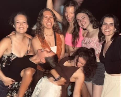 Junge Frauen tanzen nachts ausgelassen.