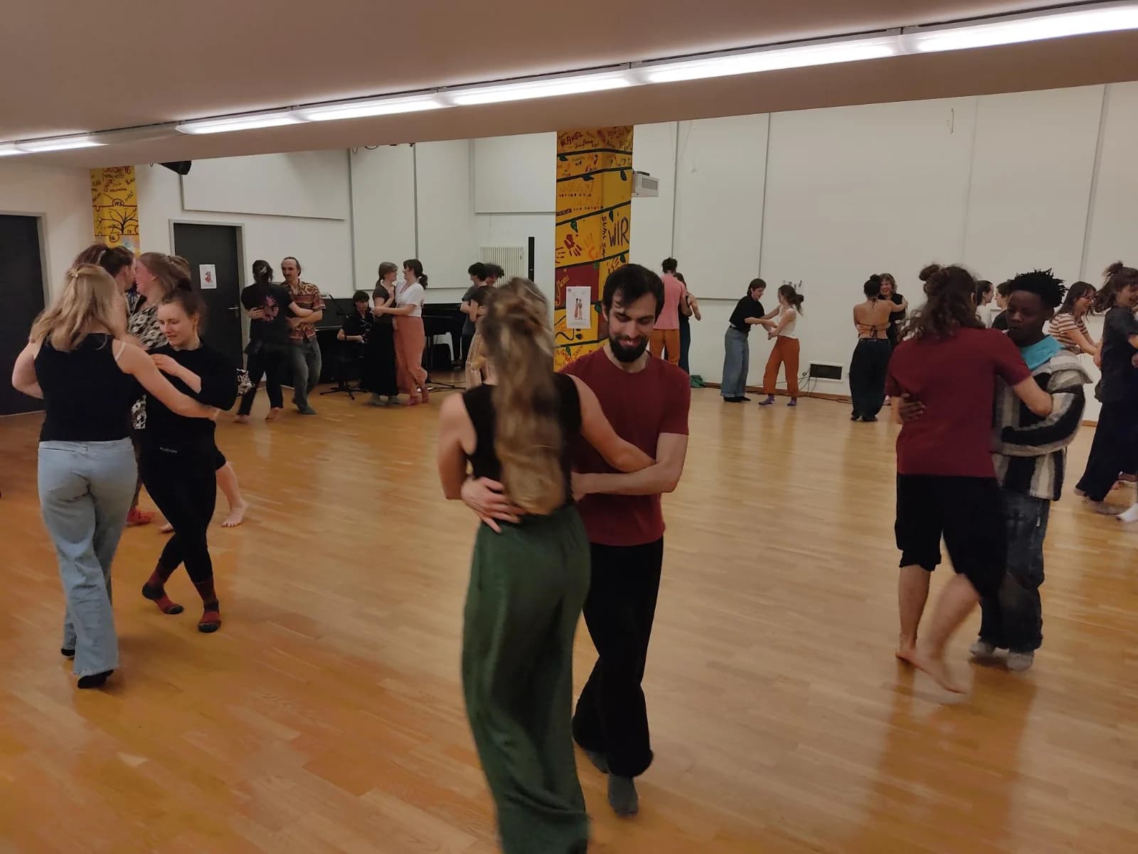 Junge Menschen tanzen in Paaren einen Kreistanz vom Bal Folk.