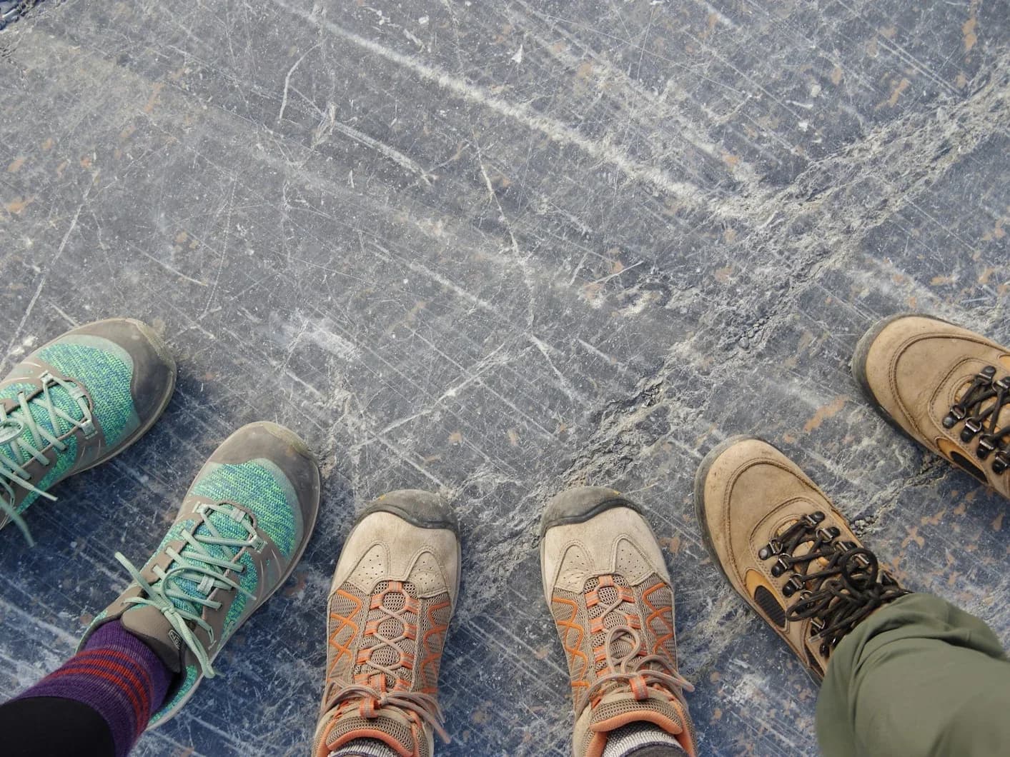Beine in Wanderschuhen und Wollsocken beim Gehen auf einem felsigen Untergrund im Nebel