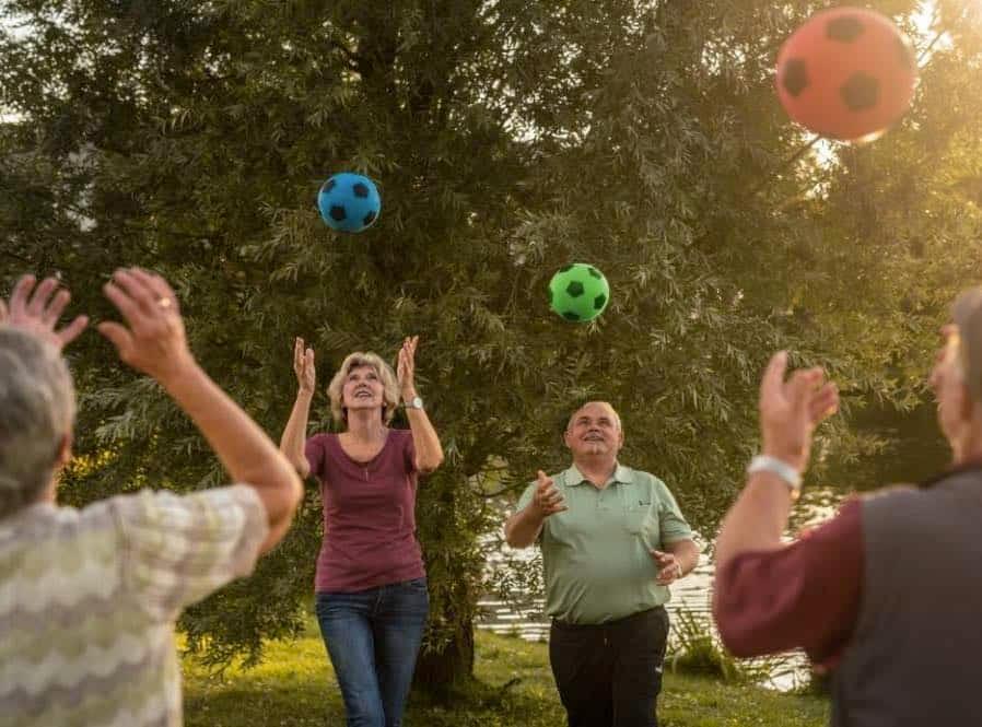 Teilnehmende Senioren, die Bälle in die Luft werfen bei der Demenzprävention von "Aktiv im Alter Gestalt" in Regensburg.