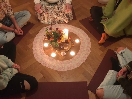 Beim Frauenkreis sitzen sechs Frauen um eine Mitte mit Kerze.