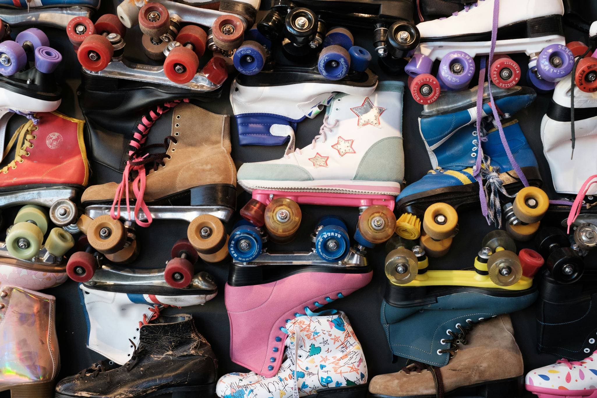 Viele alte Rollschuhe liegen nebeneinander.