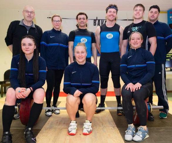 Eine Gruppe von Männer und Frauen beim Training des olympischen Gewichtheben.