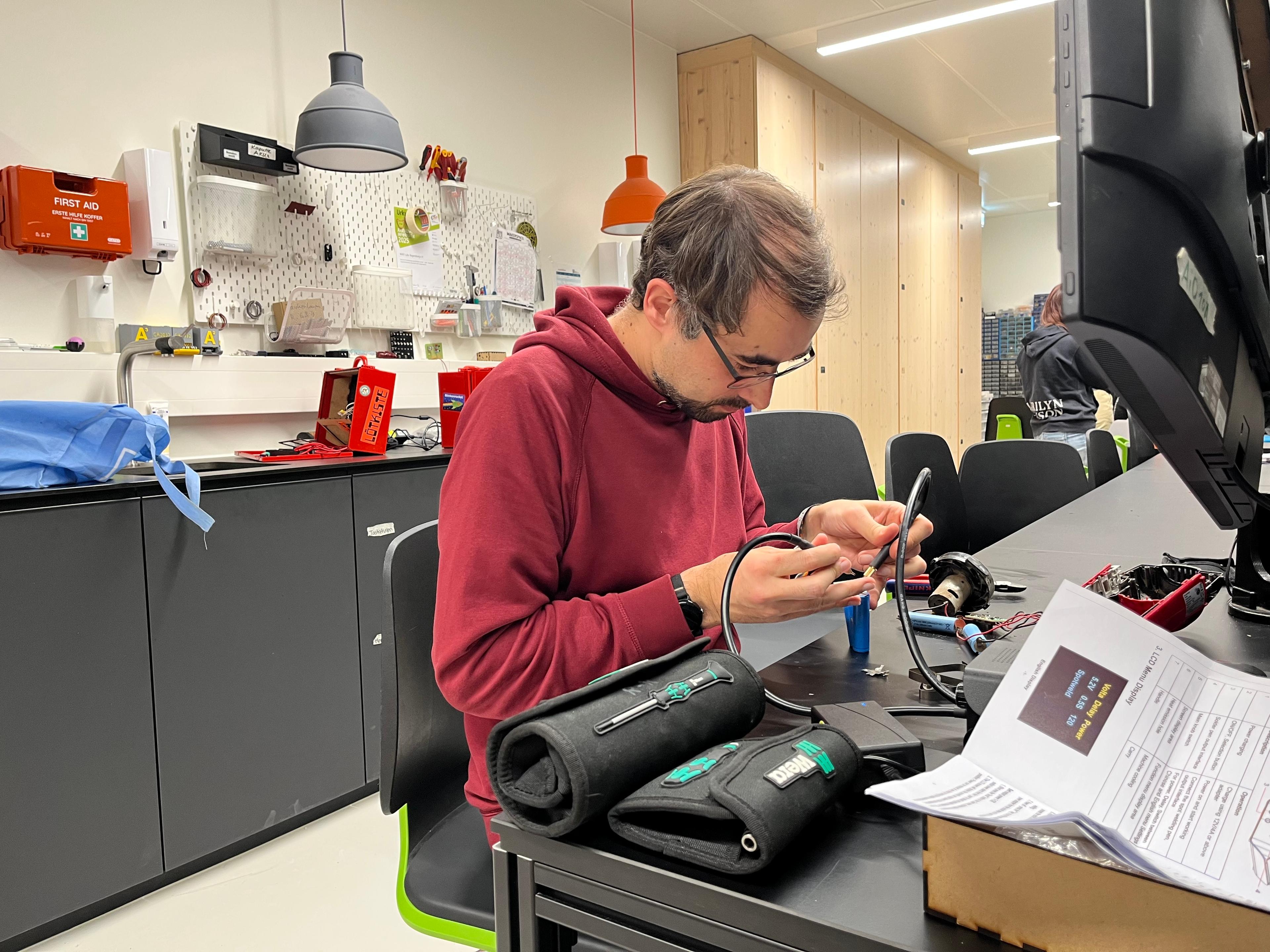 Eine Hand mit Schraubenzieher die gerade eine Mainboard repariert, stellvertretend für die Reparaturinitiative Regensburg.