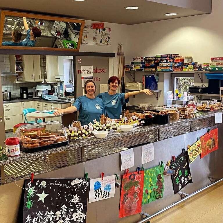 Zwei Frauen vom Familiencafé Herztöne präsentieren das angebotene Frühstück auf der Theke.