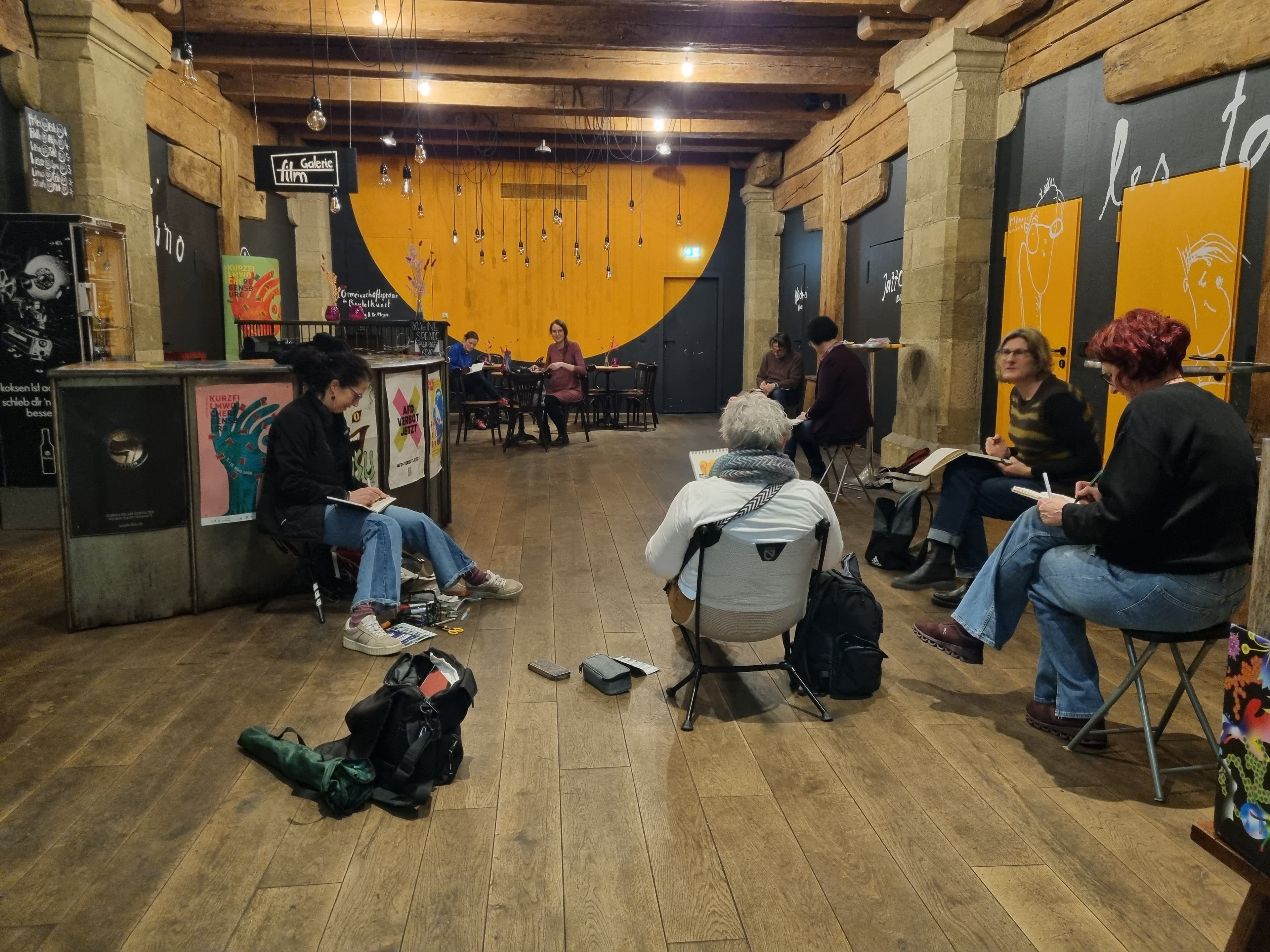 Viele Urban Sketchers zeichnen in einem bunten Raum.