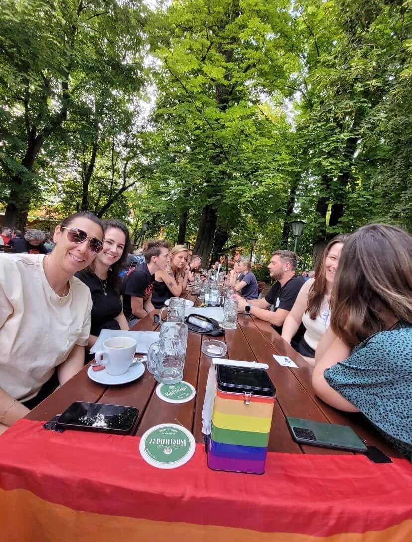 Beim queeren Stammtisch Regensburg sitzen Menschen im Biergarten beisammen.
