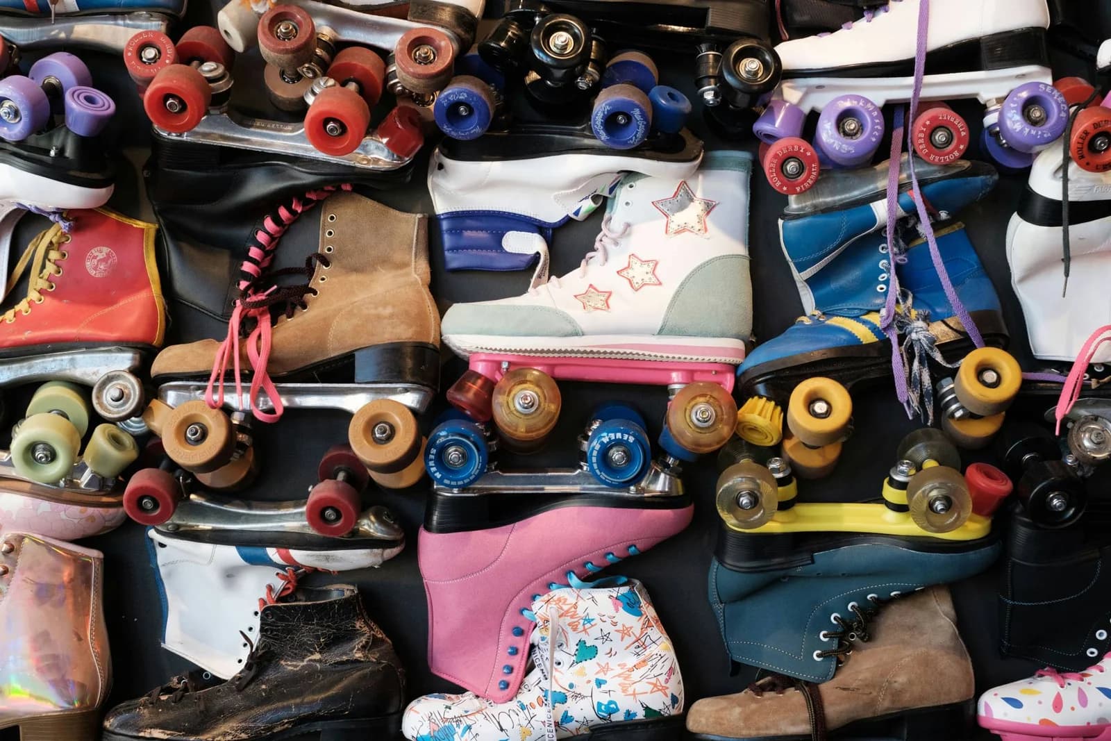 Viele alte Rollschuhe liegen nebeneinander.