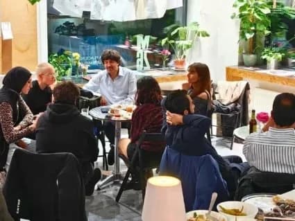 Menschen sitzen im interkulturellen Stammtisch.
