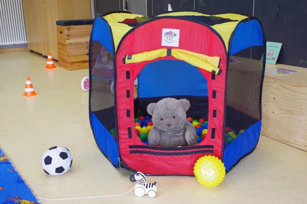 Eine Bällebad mit einem Stofffussball, sowie einen Teddy-Bären in der offenen Kinderspielewelt im Familienzentrum Herztöne in Burgweinting, Regensburg