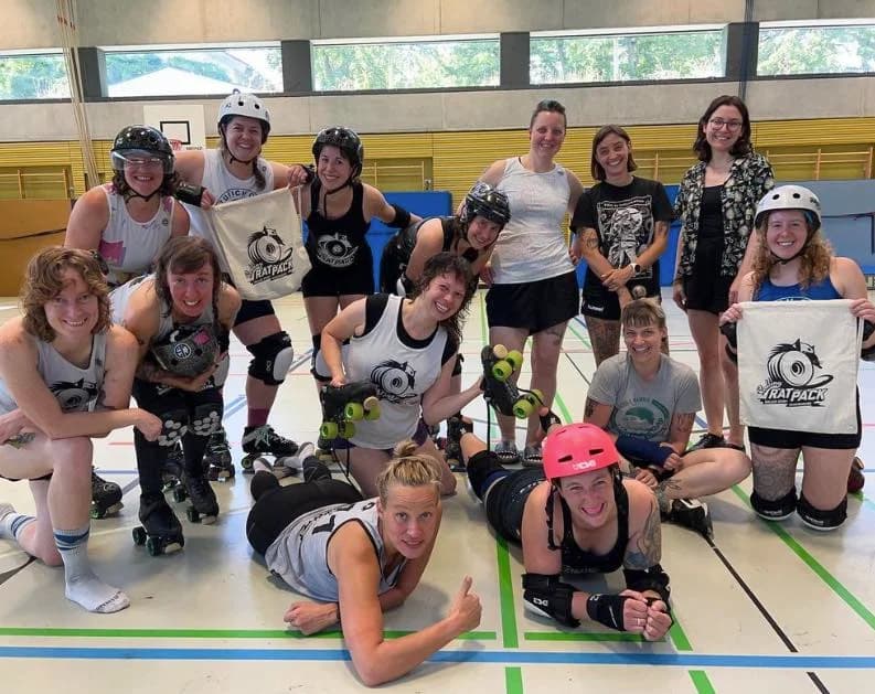 Ein Team-Bild vom Rolling Rat Pack in einer Regensburger Turnhalle. Dabei zeigen die Frauen Taschen mit dem Logo des Vereins.