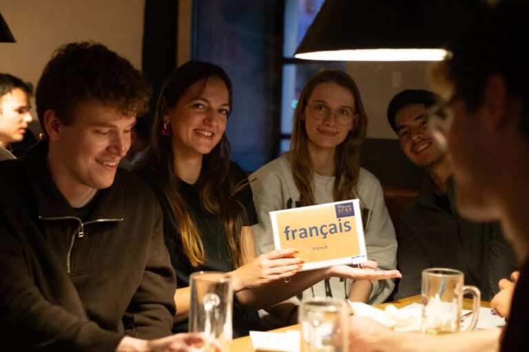 Eine Gruppe junger fröhlicher Leute im Sprachcafé in der Alten Mälze am Französisch-Tisch.