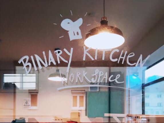 Eine Fensterscheibe mit der Aufschrift "Binary Kitchen Workspace".