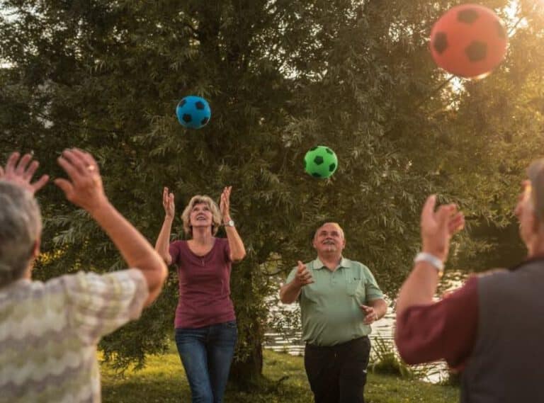 Teilnehmende Senioren, die Bälle in die Luft werfen bei der Demenzprävention von "Aktiv im Alter Gestalt" in Regensburg.