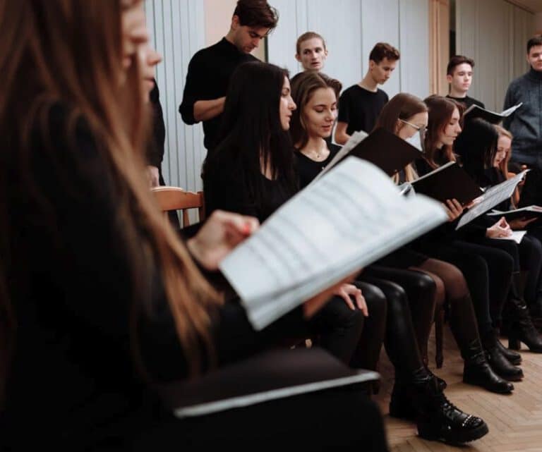 Eine Chor-Gruppe in schwarzen Kleidern beim Proben, stellvertretend für "Singen im Chor" in Regensburg im Mehrgenerationenhaus (MGH).