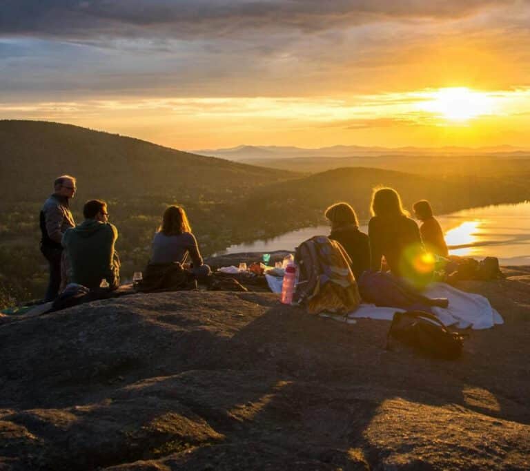 Eine Gruppe von Menschen vor einem Sonnenuntergang in der Natur stellvertretend für Human Home in Regensburg.