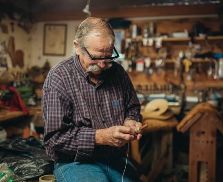 Ein Senior mit Brille, der in der Werkstatt ist stellvertretend für den Seniorentreff.