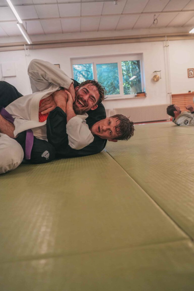 Zwei Kampfsportler trainieren Jiujitsu.