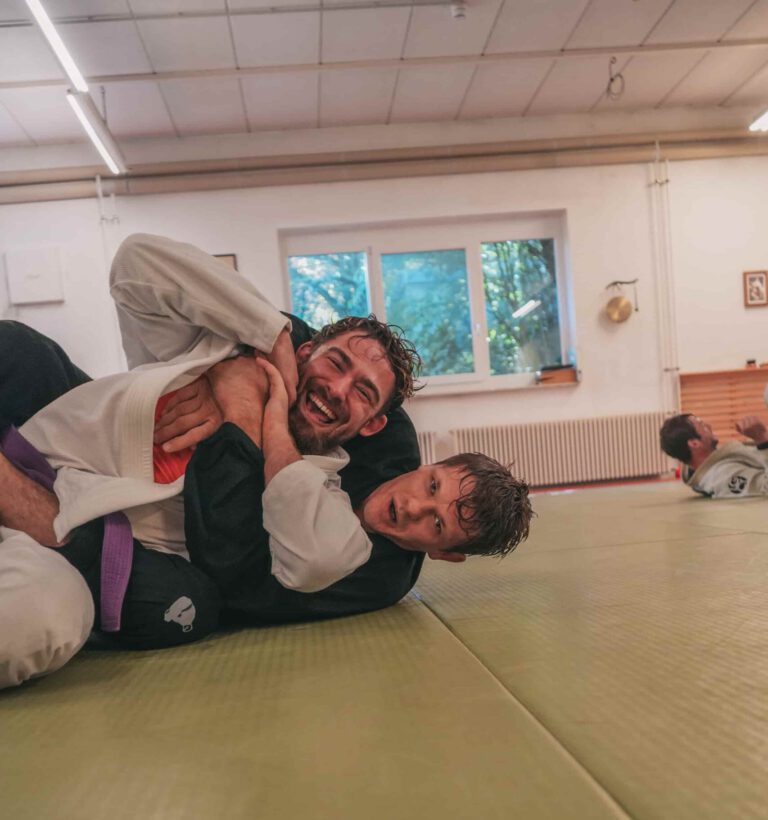 Zwei Kampfsportler trainieren Jiujitsu.