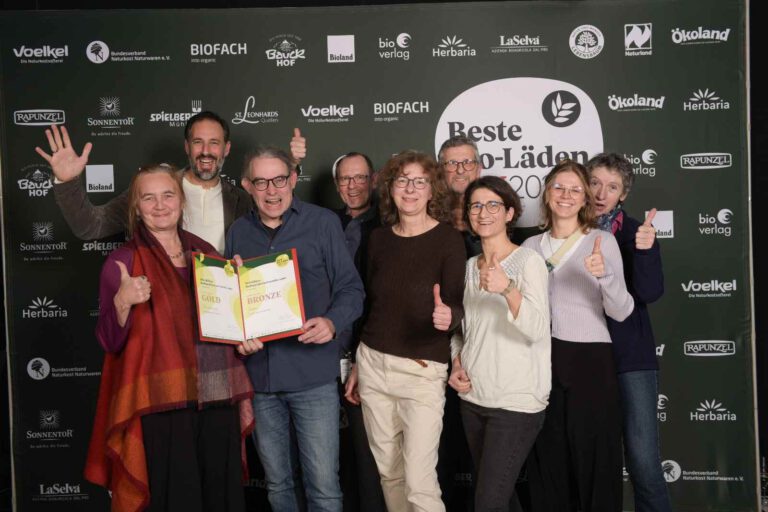 Die ehrenamtlichen Mitarbeiter des Genossenschaftsladens präsentieren freudig ihre Auszeichnung auf der Bio Fachmesse.