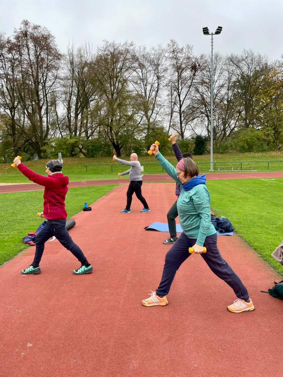 Senioren treiben Sport auf dem Sportplatz.